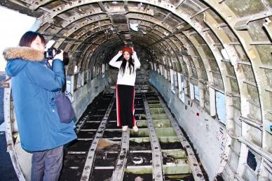 chinesische Touristen posen in der alten DC 3 bei Solheimasandar