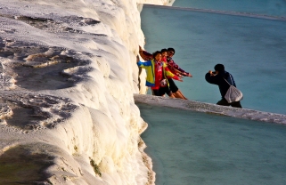 Touristen in den Kalksinterterrassen in Pamukkale, Tuerkei